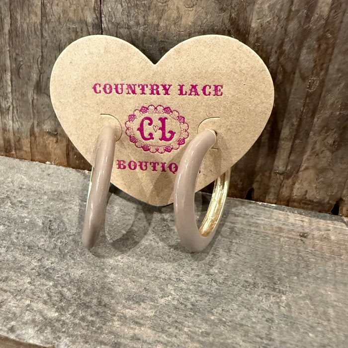 Heart-shaped earrings on a Country Lace Boutique card against a wooden background