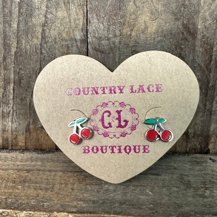 Heart-shaped card with 'Country Lace Boutique' branding and cherry designs on a wooden background