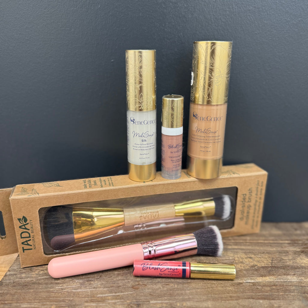 Makeup products including bottles and brushes on a wooden surface with a dark gray background