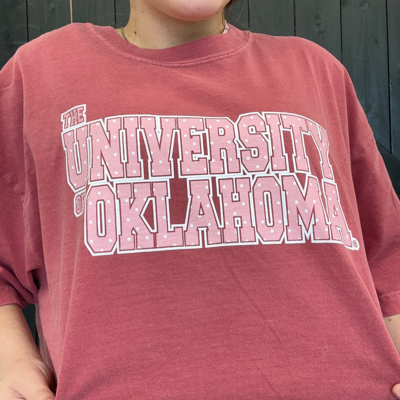 Red sweatshirt with 'The University of Oklahoma' printed on it against a dark background