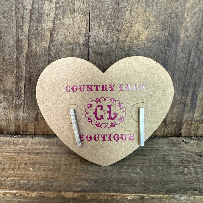 Heart-shaped card with earrings on a wooden background, featuring 'Country Lace Boutique' branding.
