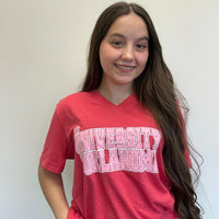 Person wearing a red 'University of Oklahoma' shirt against a white background