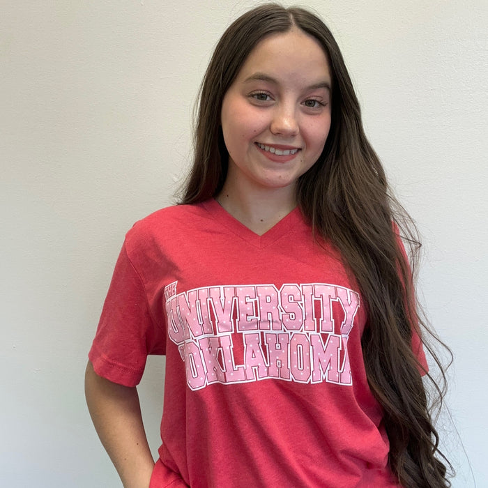Person wearing a red 'University of Oklahoma' shirt against a white background