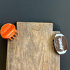 Wooden block with a basketball and football magnet on a dark background