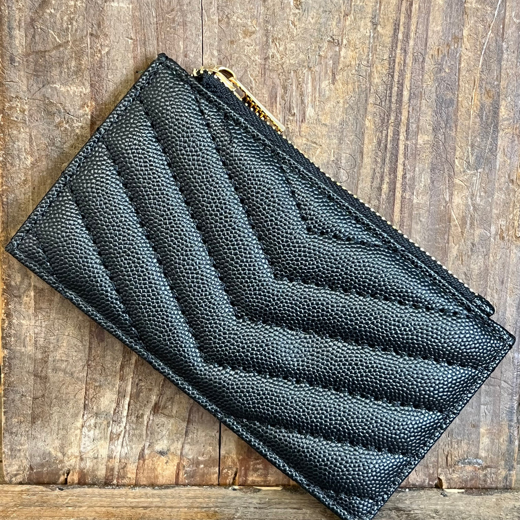 Black textured wallet on a wooden surface