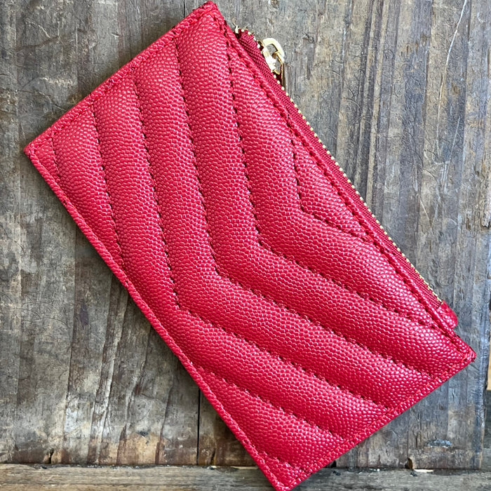 Red quilted wallet on a wooden surface