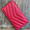 Red quilted wallet on a wooden surface
