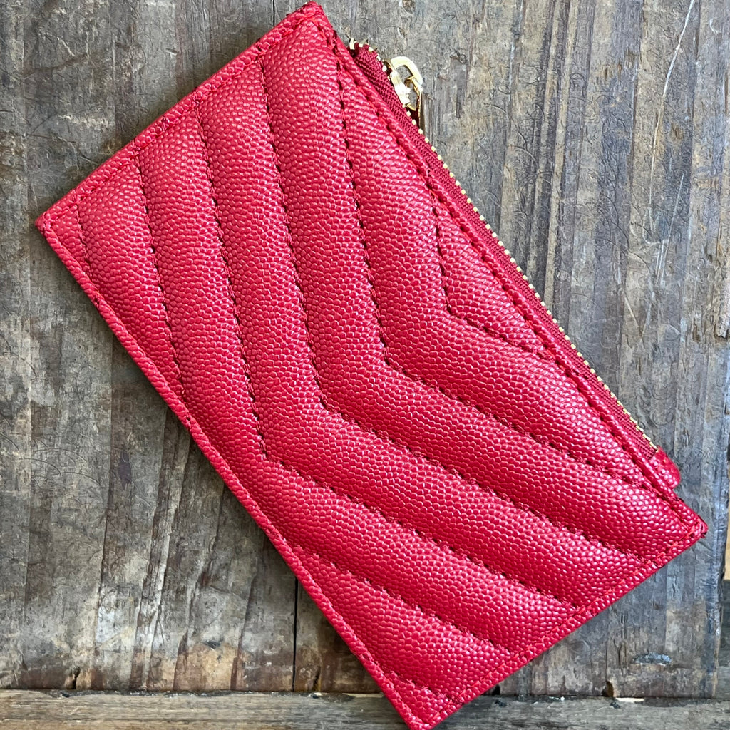 Red quilted wallet on a wooden surface