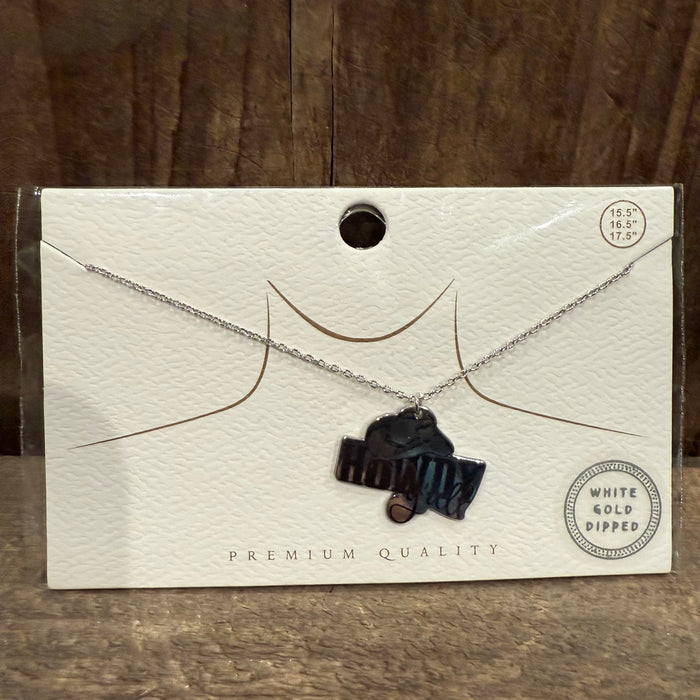 Necklace with pendant on a white card against a wooden background