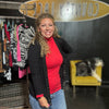 Woman standing in a store with clothing and a 'Country Lace' sign in the background