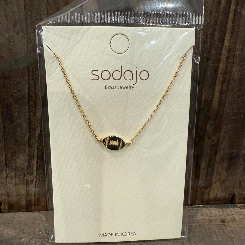 Gold necklace on a sodajo branded card with a wooden background