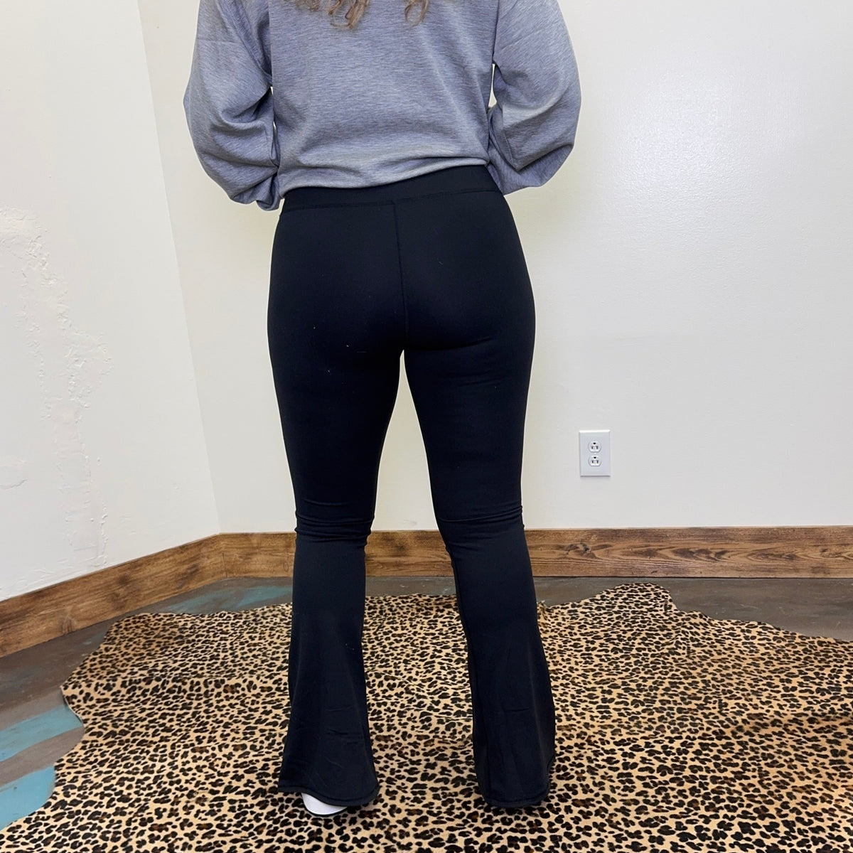  black leggings standing on a leopard print rug.