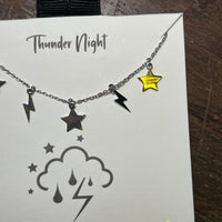 Necklace with star and lightning bolt charms on a 'Thunder Night' card.
