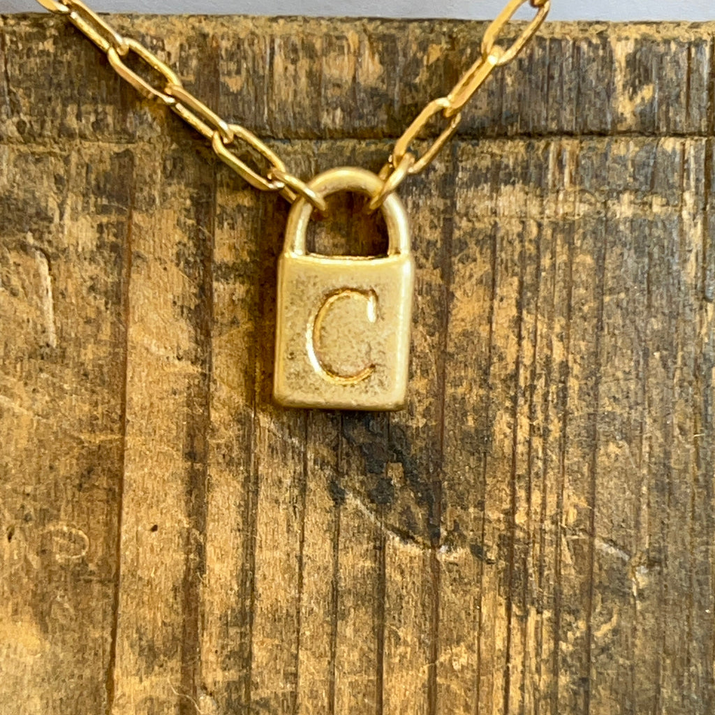 Gold padlock with chain on a textured wooden surface