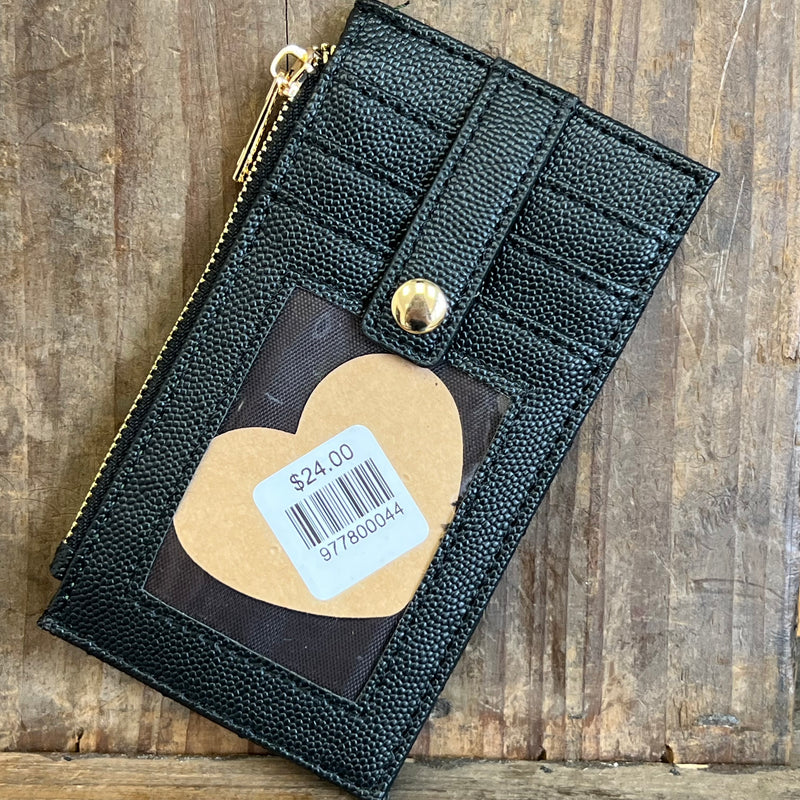 Black textured wallet with a heart-shaped tag displaying a price on a wooden surface