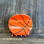 Ceramic elephant with basketball design on a wooden surface