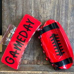 Red football-shaped container with 'GAMEDAY' text on a wooden background