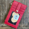 Red leather wallet with a heart-shaped tag on a wooden surface