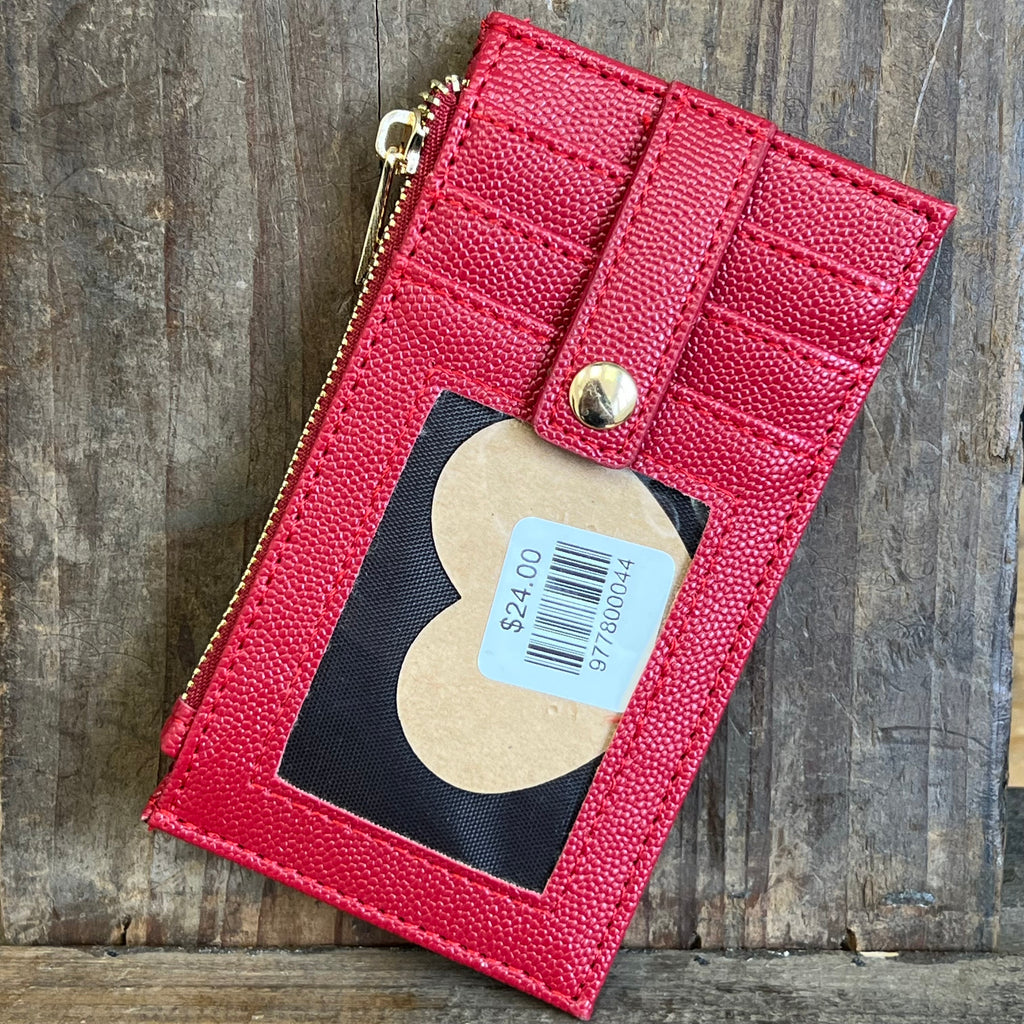 Red leather wallet with a heart-shaped tag on a wooden surface