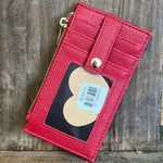 Red leather wallet with a heart-shaped tag on a wooden surface