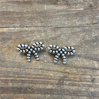 Silver beaded earrings on a wooden surface
