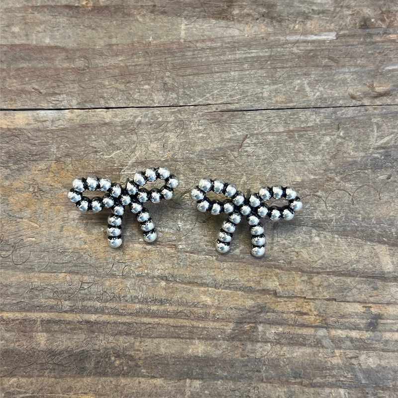 Silver beaded earrings on a wooden surface