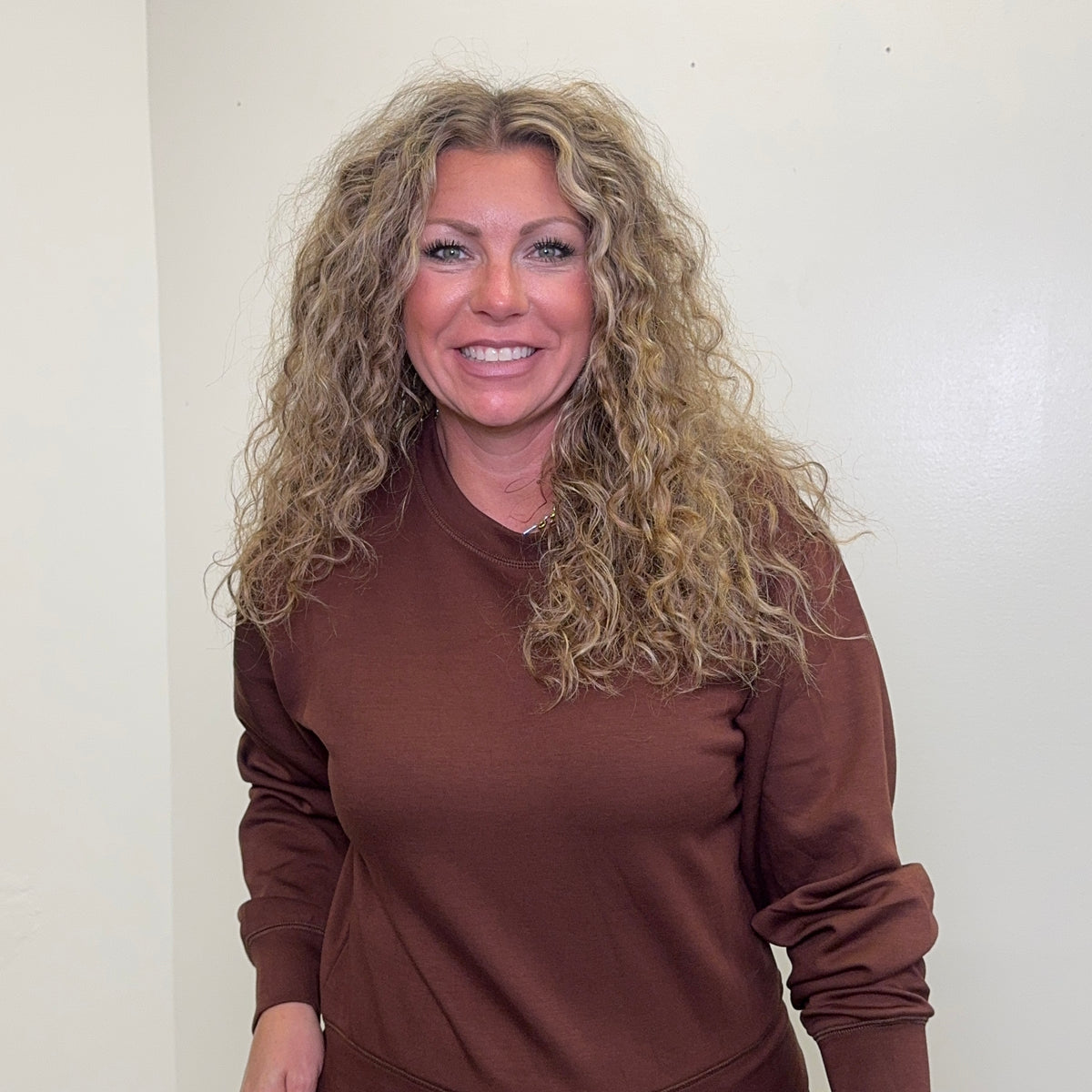 Woman wearing a brown outfit against a plain background