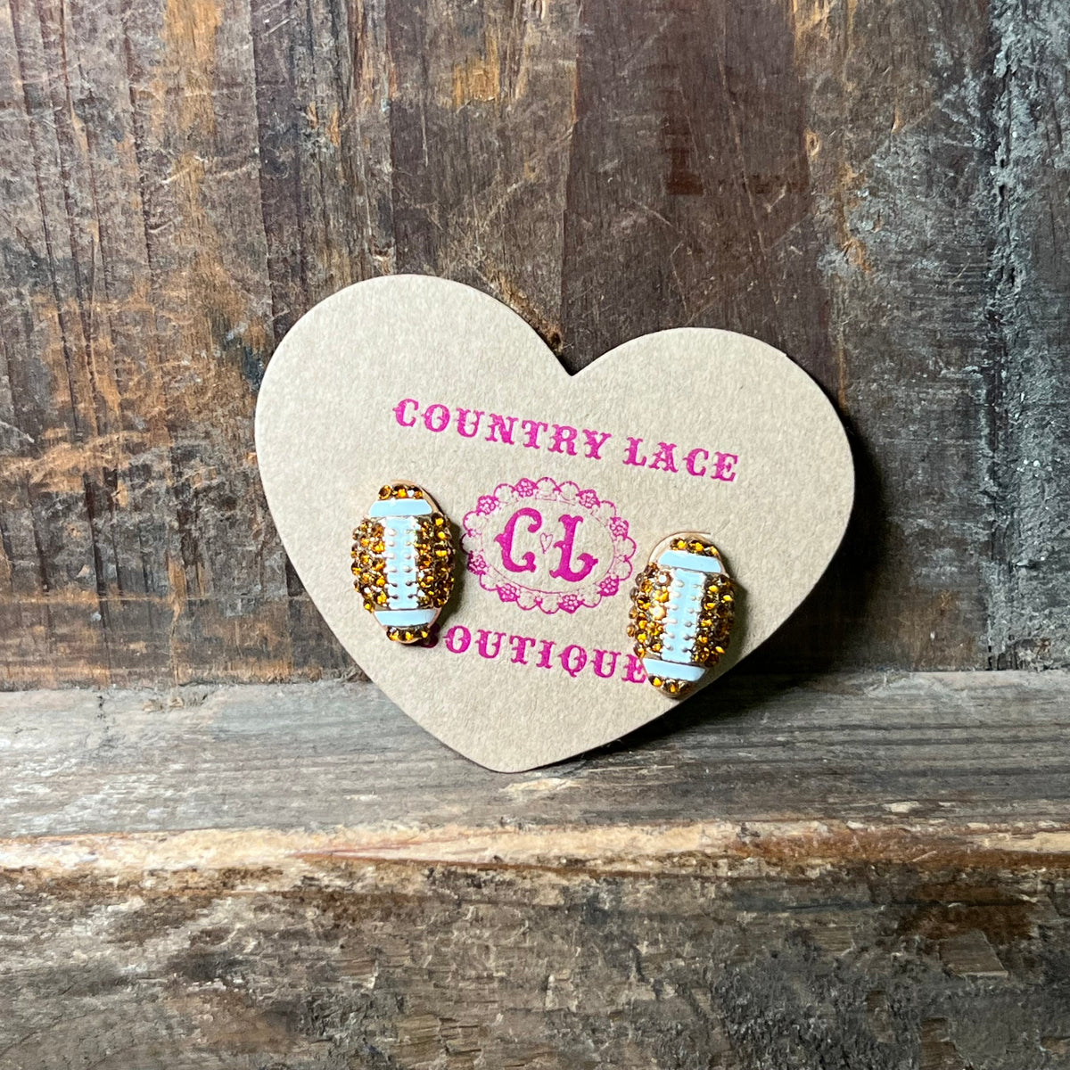 Heart-shaped card with earrings on a wooden surface