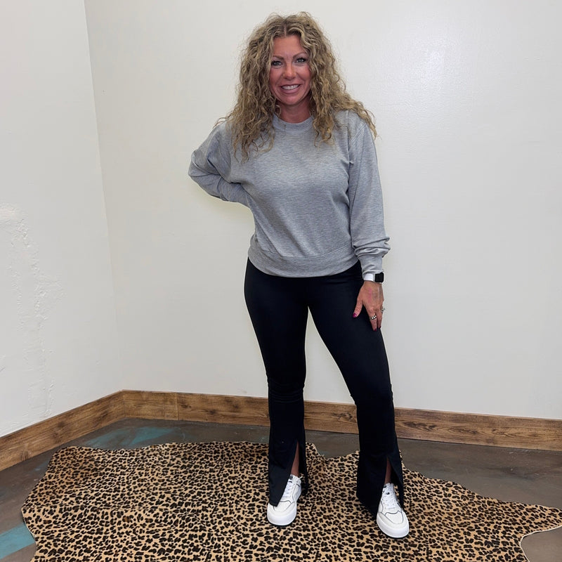 Woman standing on a leopard print rug in a room with white walls and wooden trim.