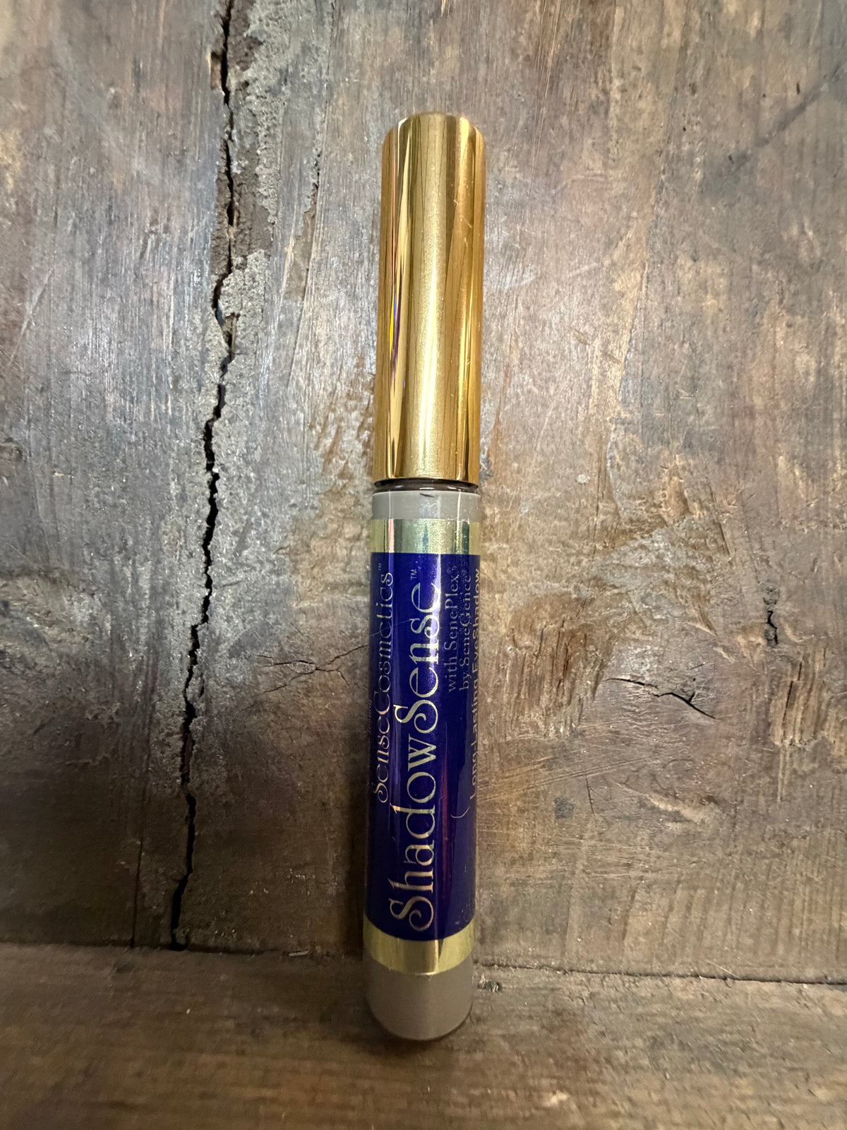 Gold and blue cylindrical object on a wooden surface
