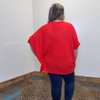 red sweater and blue jeans standing in a room with a leopard print rug.