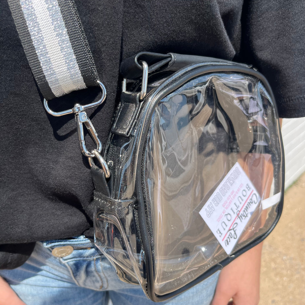 Clear pouch with a visible brand label attached to a person wearing a black jacket.