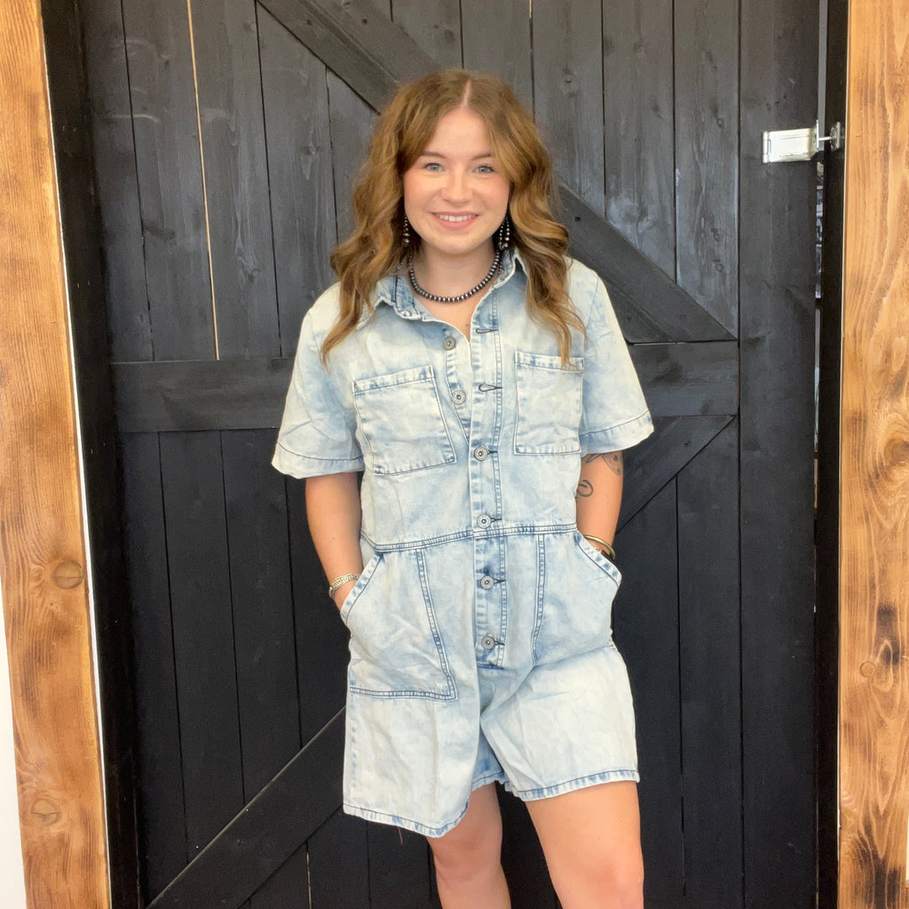 Woman wearing a denim outfit standing in front of a wooden door.