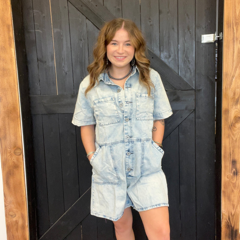 Woman wearing a denim outfit standing in front of a wooden door.