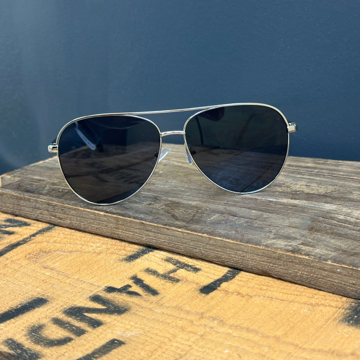 Aviator sunglasses on a wooden surface with a blue background