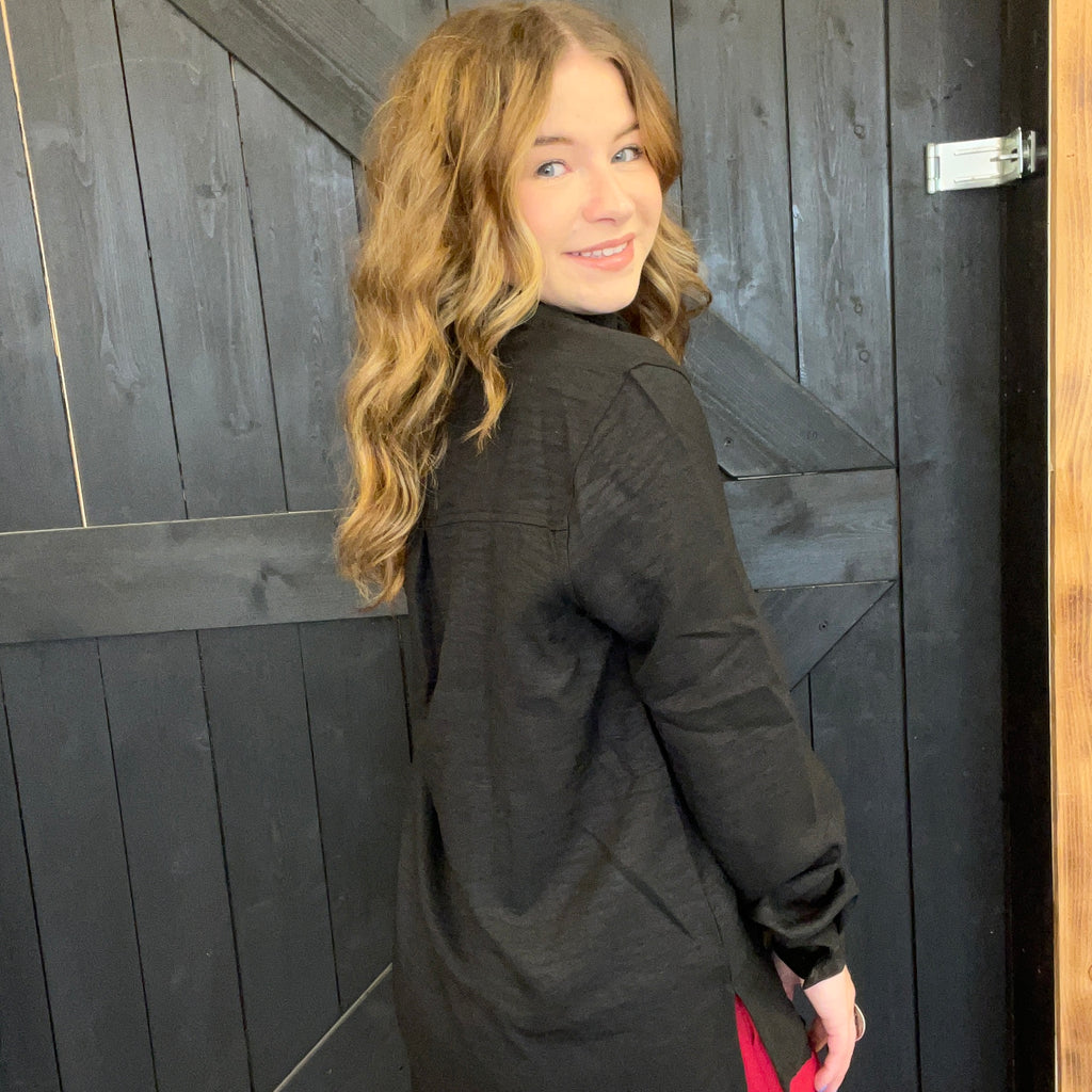 Woman wearing a black jacket standing in front of a wooden door
