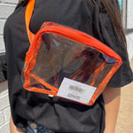 Person wearing a clear pouch with orange trim on a black shirt