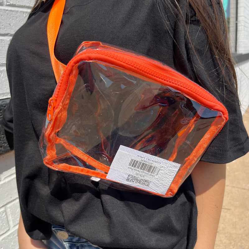 Person wearing a clear pouch with orange trim on a black shirt