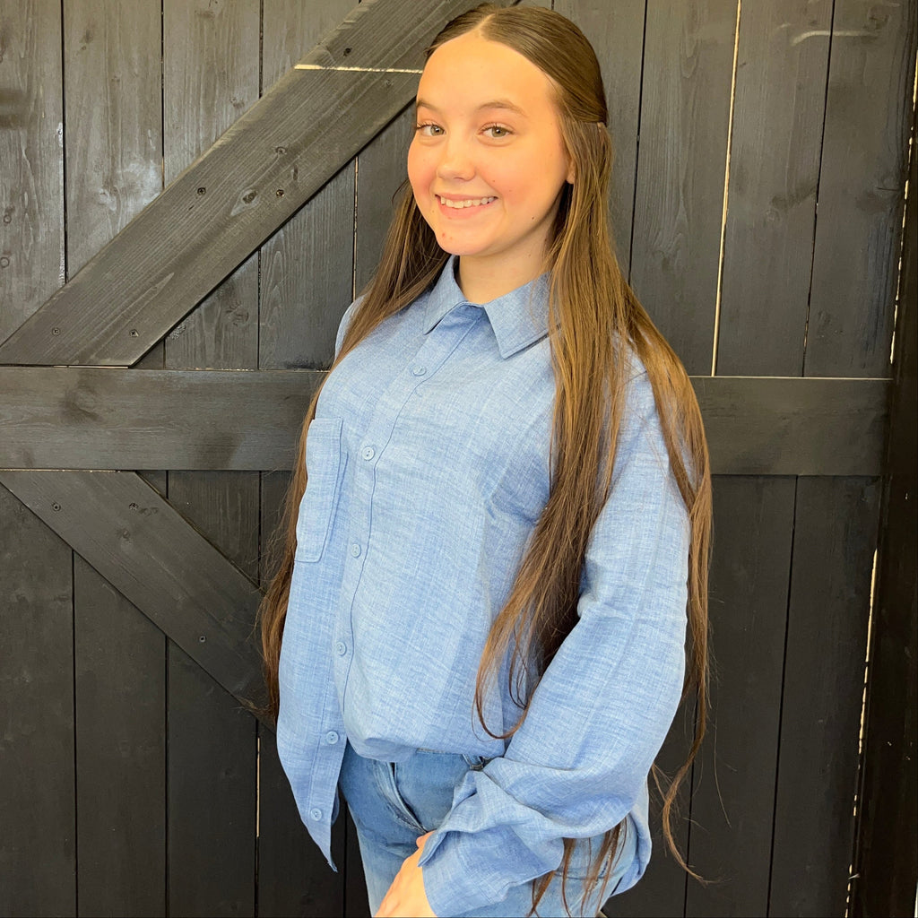 Person wearing a blue shirt standing in front of a wooden door