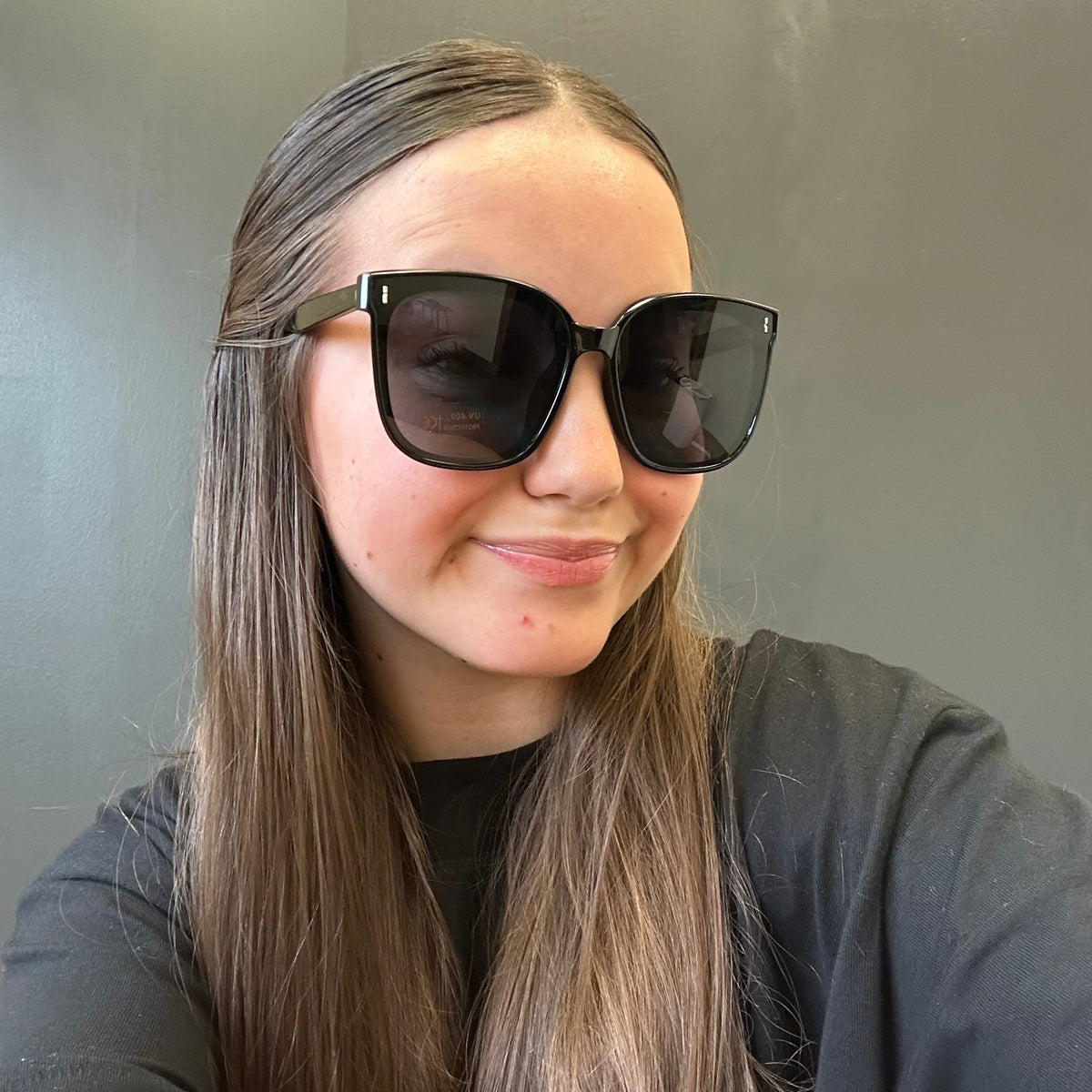 Person wearing large sunglasses with a neutral background