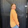 Woman in a yellow sweater standing in front of a wooden door