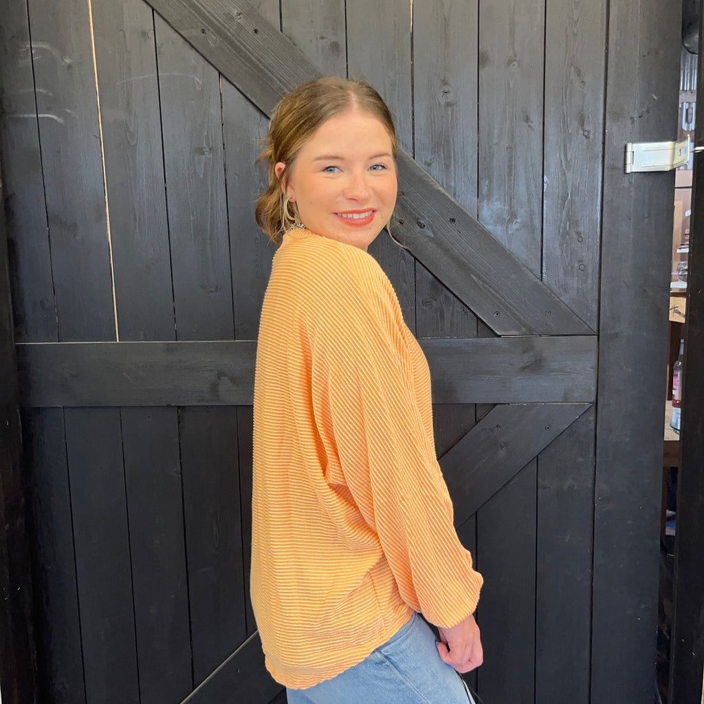 Woman in a yellow sweater standing in front of a wooden door