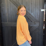 Woman in a yellow sweater standing in front of a wooden door