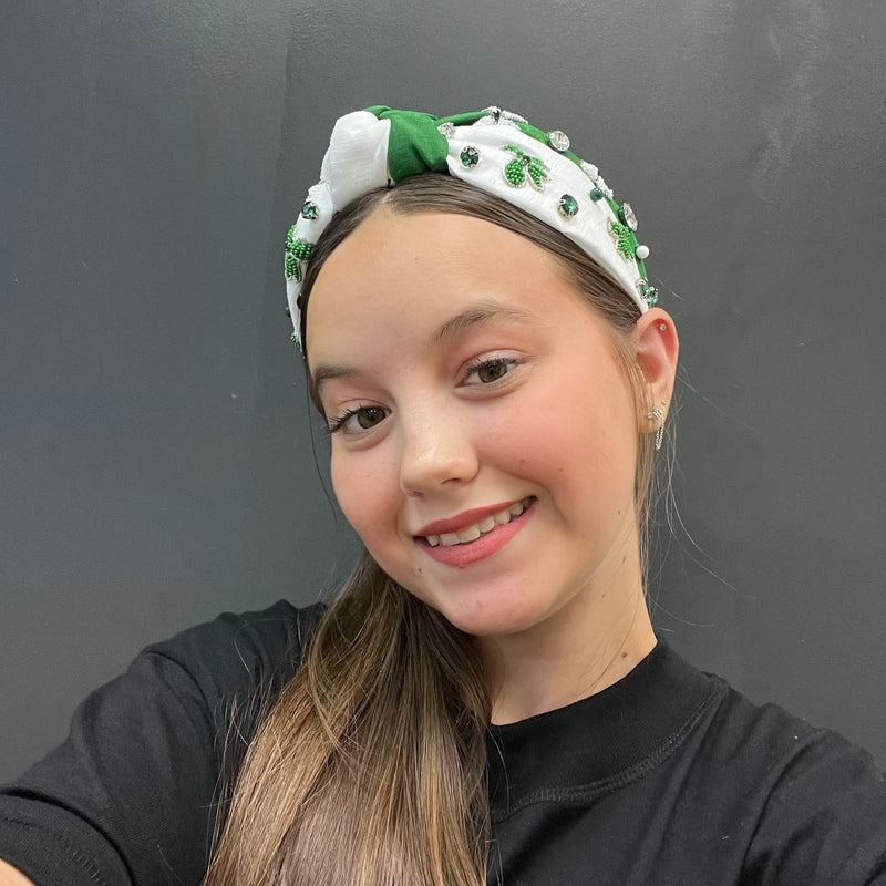 Person wearing a decorative headband with a plain background