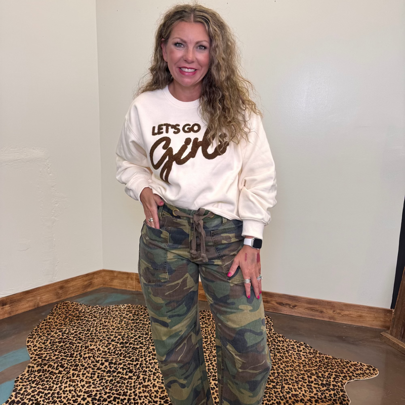 white sweatshirt with 'Let's Go Girl' text and camouflage pants 