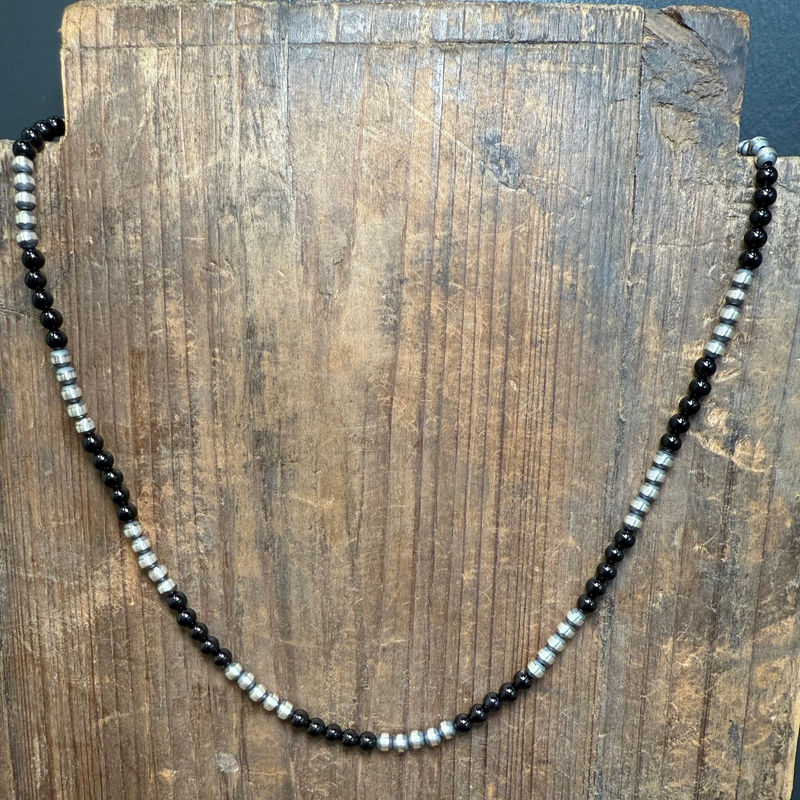 Necklace with black and white beads on a wooden surface