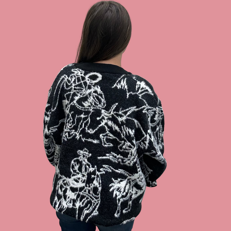 Person wearing a black sweater with white floral patterns against a plain background