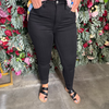 Person wearing black jeans standing in front of a floral wall.