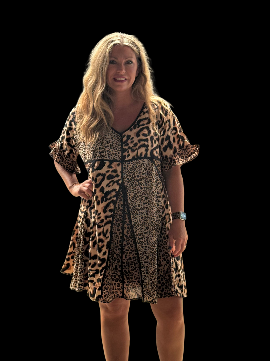 Woman wearing a leopard print dress in an indoor setting with a blue curtain and wooden beams.