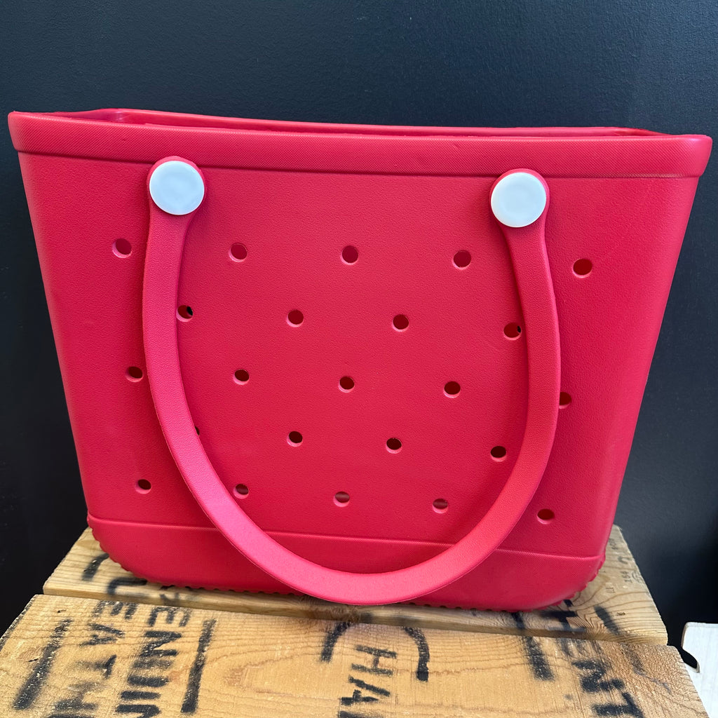 Red bag with white handles on a wooden surface